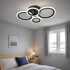 Lustra LED neagra patru cercuri 60W cu telecomanda, montata in dormitor modern, lumina ajustabila 3000-6500K pentru ambient confortabil