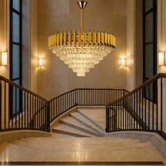 Candelabru piramidal auriu cu cristale, luminand amplu o casa a scarilor mare si luxoasa.