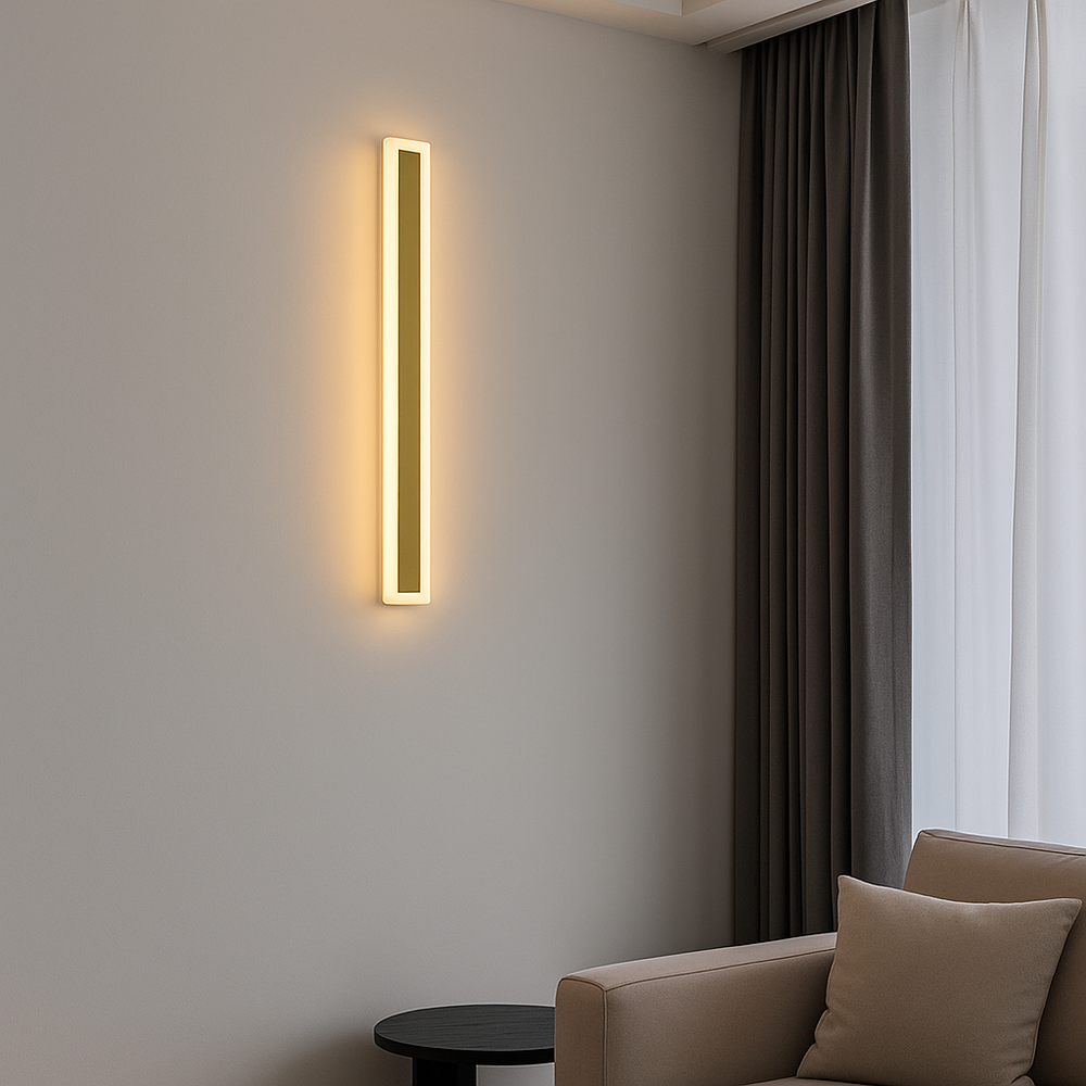 Aplica LED 71103/900PLG aurie, design vertical 900mm, lumina calda 3000K, montata pe perete in living modern cu accent decorativ.
