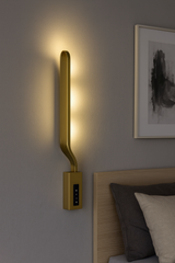 Aplica LED LUBAN Aura Gold 18W, design alungit auriu satinat, montata in dormitor modern pentru lumina ambientala 3000–6500K