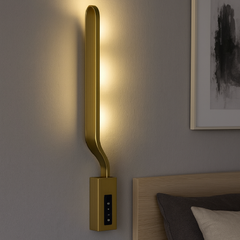 Aplica LED LUBAN Aura Gold 18W, design alungit auriu satinat, montata in dormitor modern pentru lumina ambientala 3000–6500K