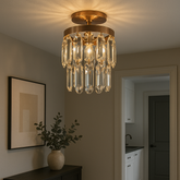 Pendul rotund auriu cu cristale si 1 bec E27, montat in hol modern, iluminare ambientala rafinata si efect vizual placut.