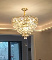 Candelabru rotund din cristal auriu Ø600 mm, cu 9 surse E27, montat central intr-un living mare cu efect regal