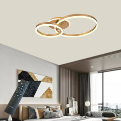 Lustra LED cu doua inele aurii si telecomanda, montata in living modern, oferind luminare eleganta si un stil decorativ contemporan.
