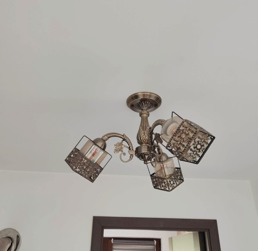 Candelabru vintage cu 3 brate din bronz antic ilumineaza un living clasic, adaugand lumina calda si un accent decorativ rafinat.