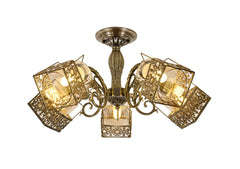 Candelabru vintage cu 5 brate bronz antic si sticla clara lumineaza livingul, oferind un accent decorativ cald si elegant.